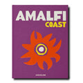 The image showcases the cover of the book "Amalfi Coast" by Assouline. With its purple background and striking white and yellow typography, it prominently features a large, abstract design of an orange and red flower. This artistic depiction captures the lively essence of the Amalfi Coast, famous for its pebble beaches and scenic trails.