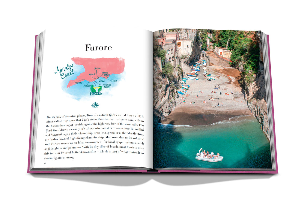 An open copy of "Amalfi Coast" by Assouline displays a colorful map on the left page, titled Furore, highlighting the breathtaking côte Amalfitaine. The right page presents a photograph capturing a beach in Furore, Italy, with its turquoise waters and sunbathers enjoying the scenic pebble shores.